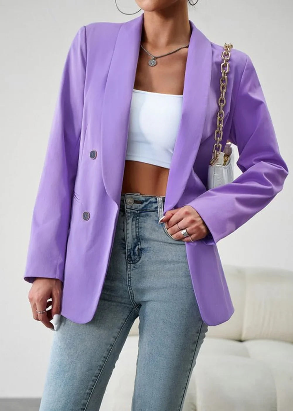 Lavender double-breasted blazer with silver buttons over a white crop top and light wash jeans.