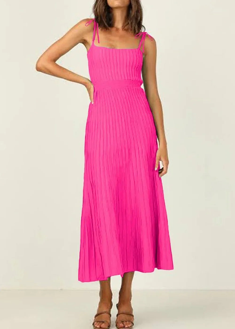 Fuchsia pleated midi dress with tie straps and a fitted waist, shown on a model.