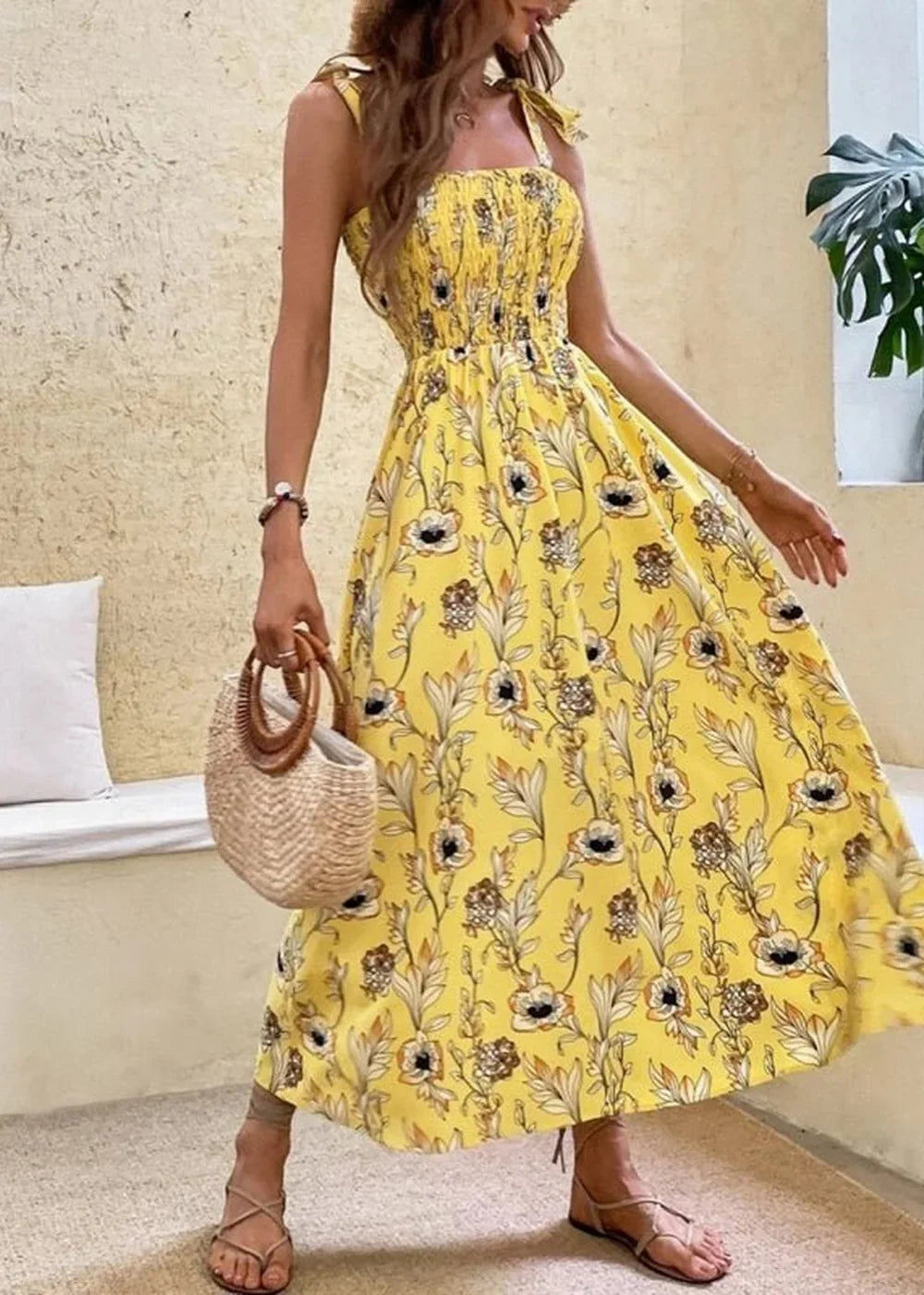 Yellow floral print maxi dress with smocked bodice and tie straps on model.