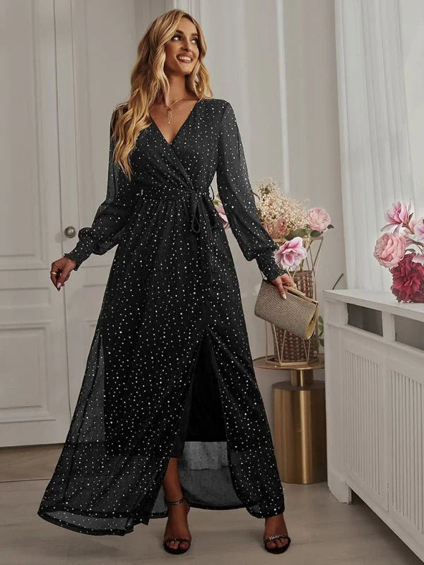 Black sparkly wrap maxi dress with a high slit on a model.