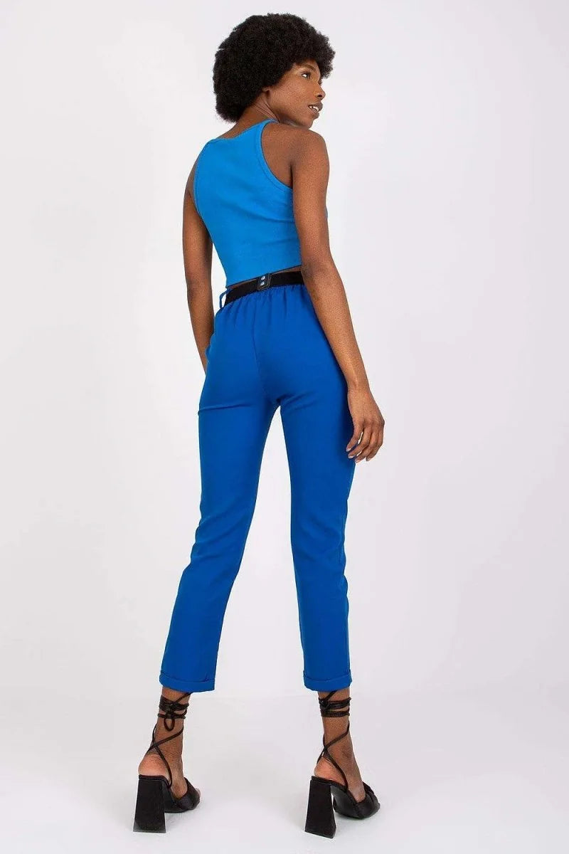 Royal blue pants with a black belt and black lace-up heels on a model.