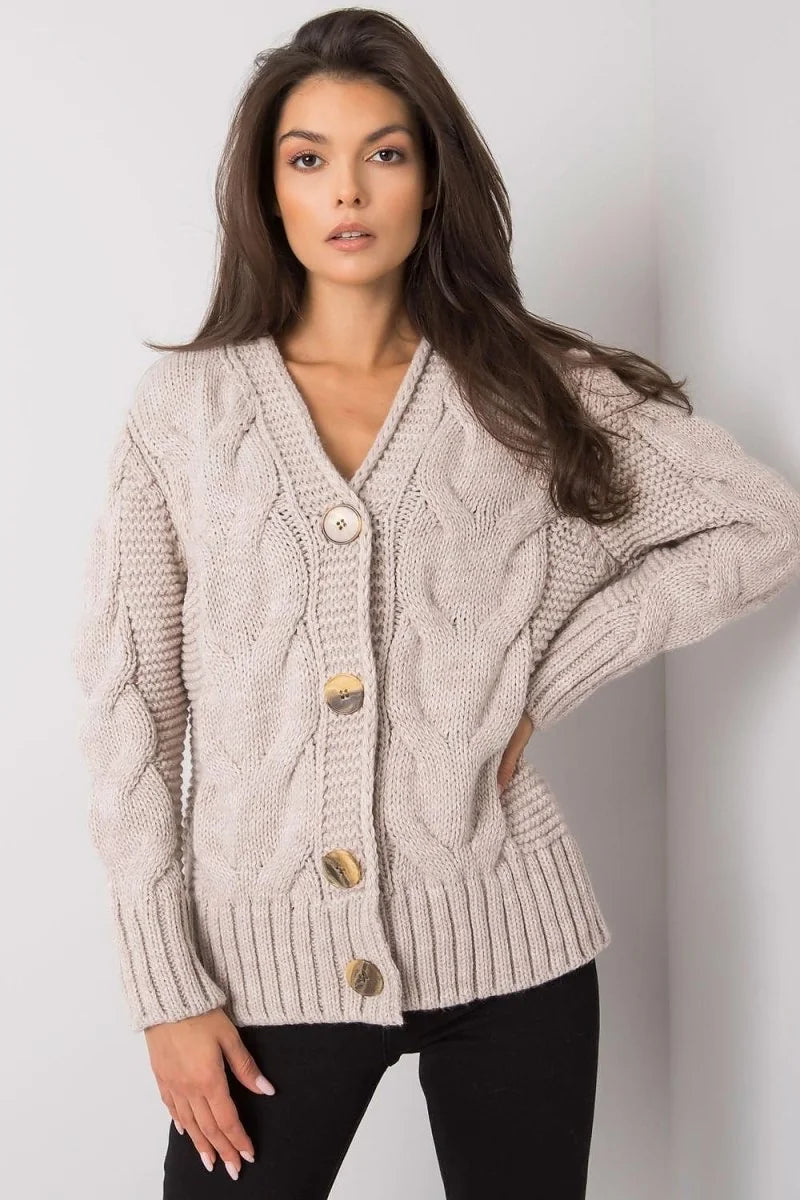 Beige cable-knit cardigan with wooden buttons, V-neck, and ribbed trim on a model.