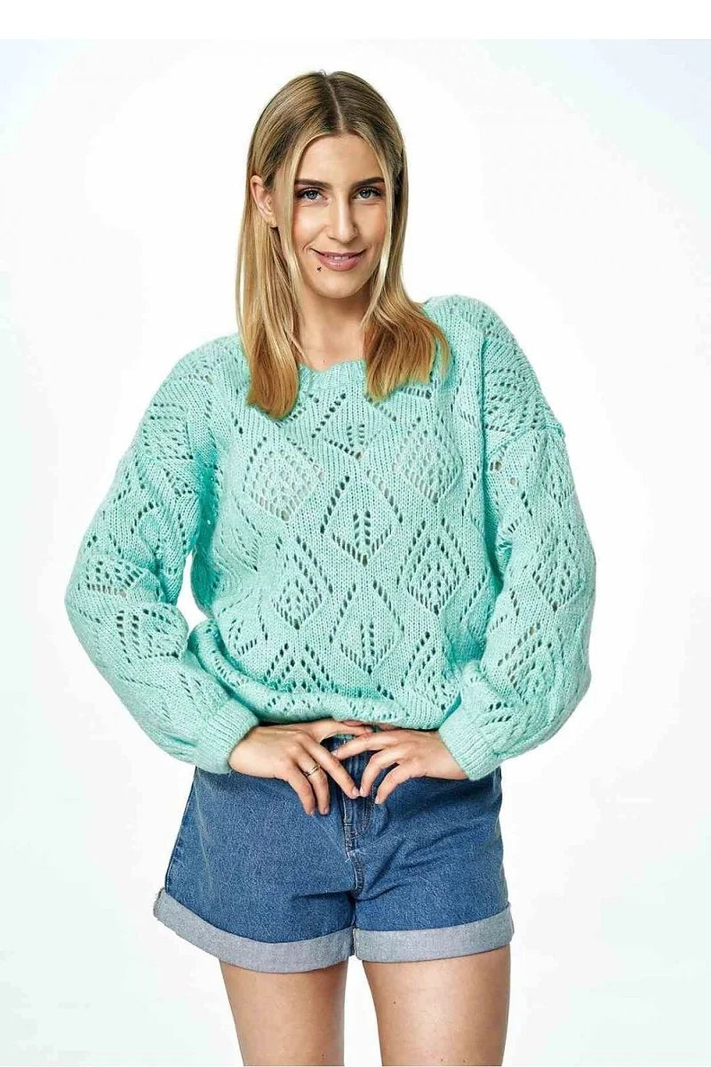 Mint green open-knit sweater with diamond pattern and rolled denim shorts on model.