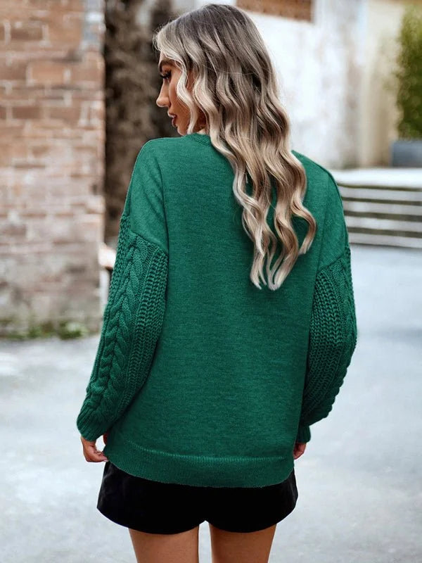 Green acrylic sweater with cable knit sleeves, shown from the back on a model.
