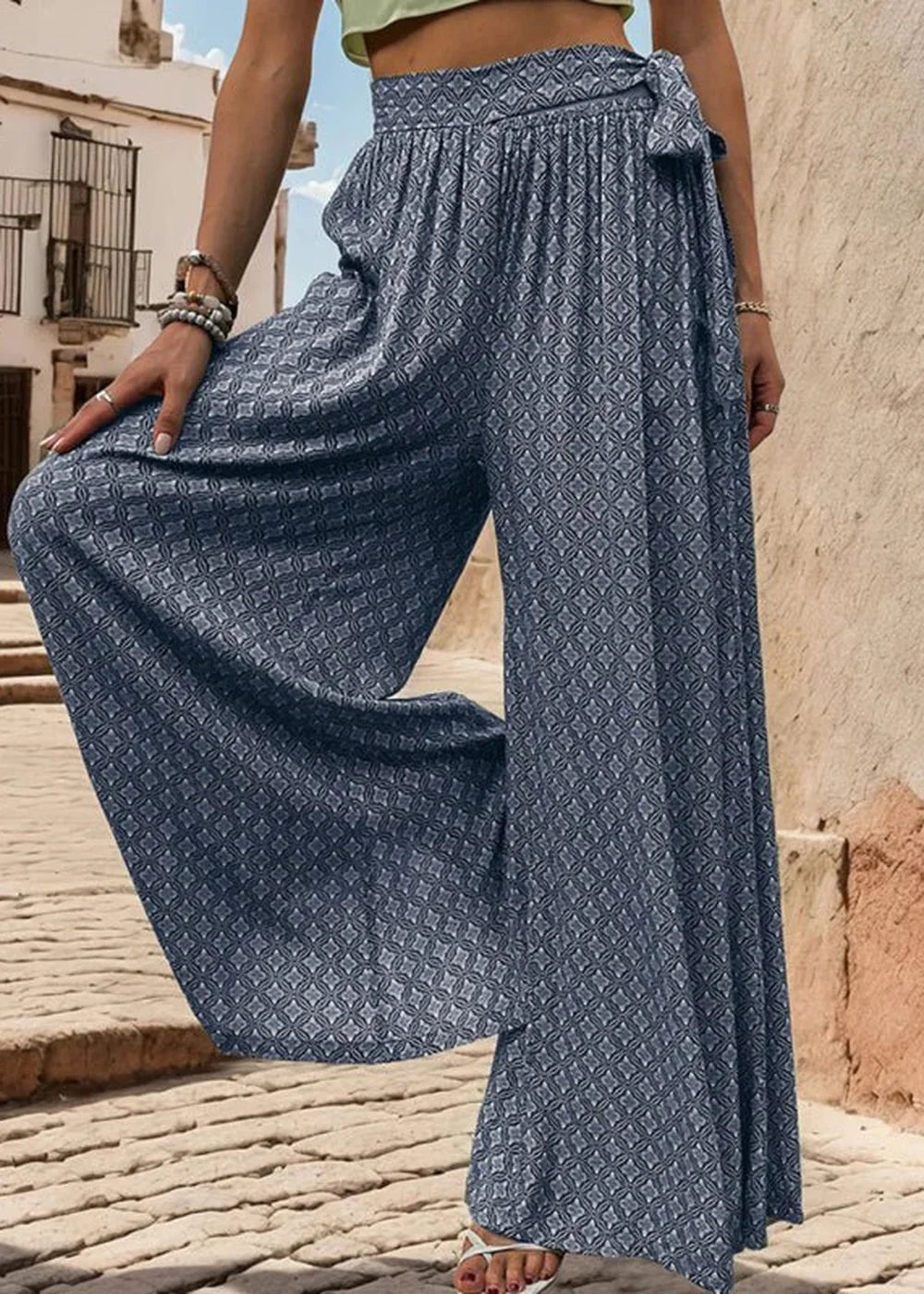 Navy blue wide-leg pants with a geometric print and a tie waist.