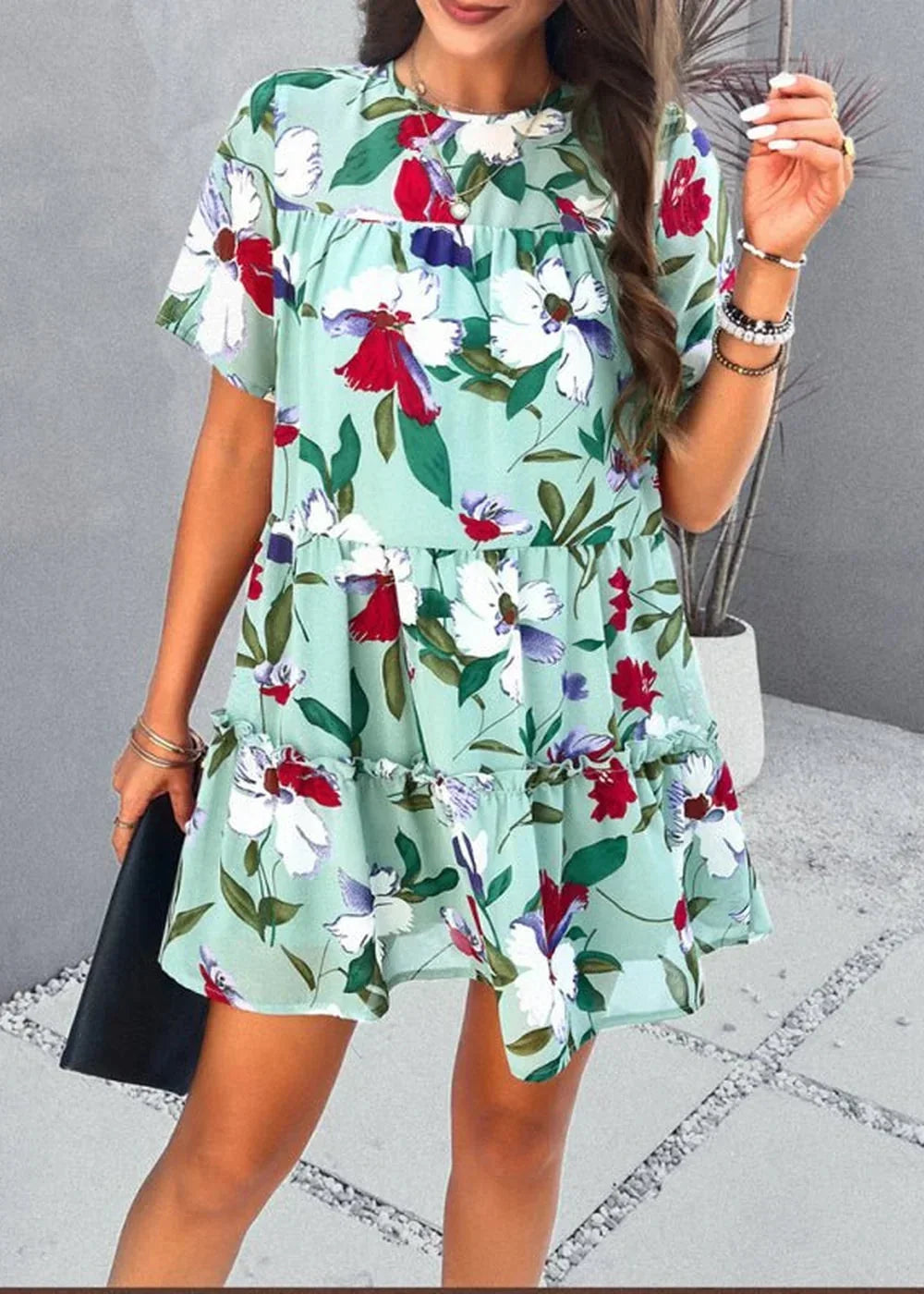 Light green floral print tiered mini dress with ruffle details, worn by a model.