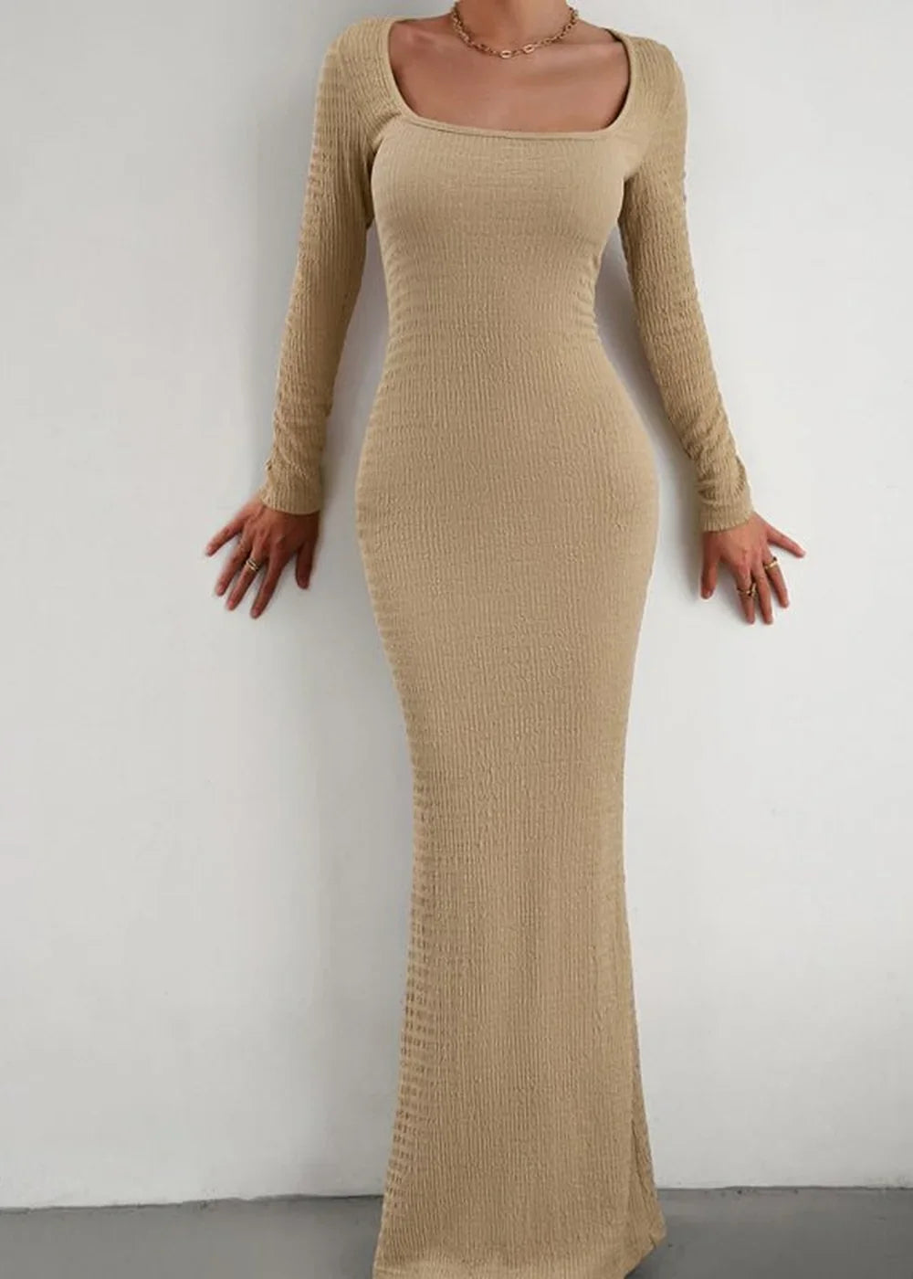 Tan ribbed maxi dress with square neckline and long sleeves, fitted to the body on a model.