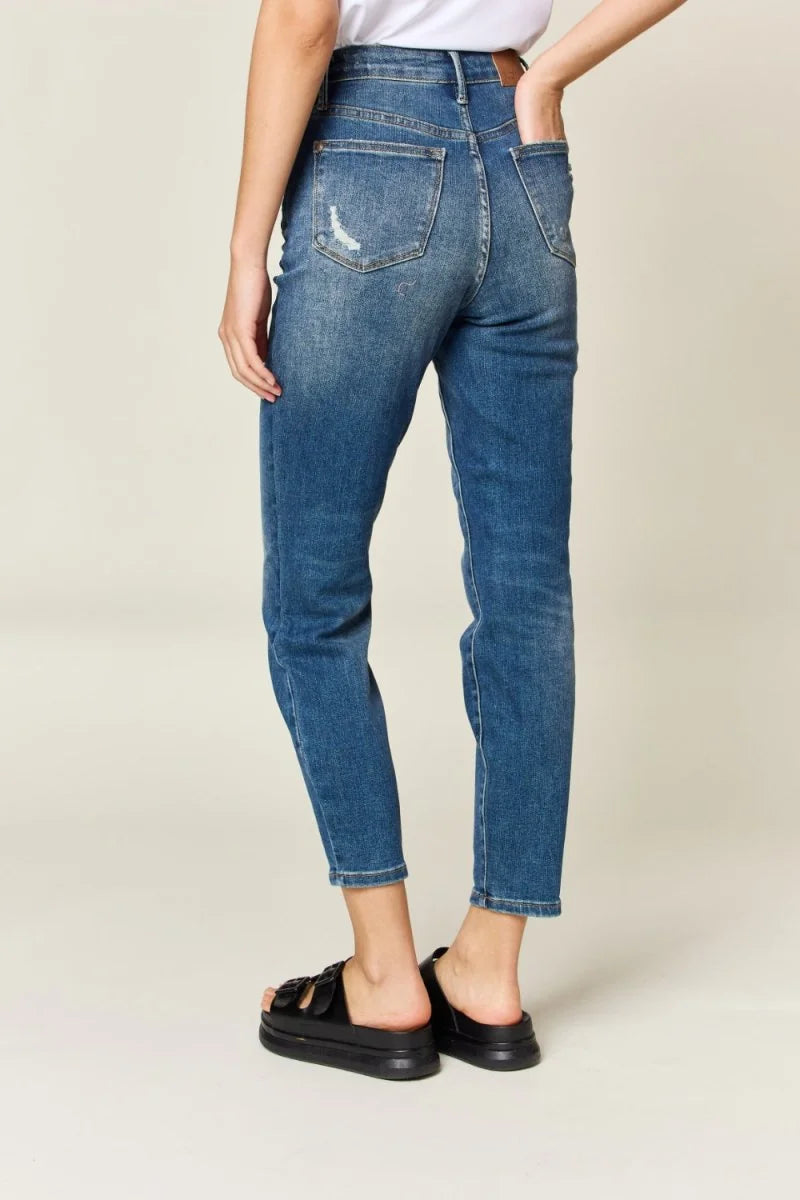 Distressed blue denim jeans, cropped length, with a relaxed fit and black platform sandals.