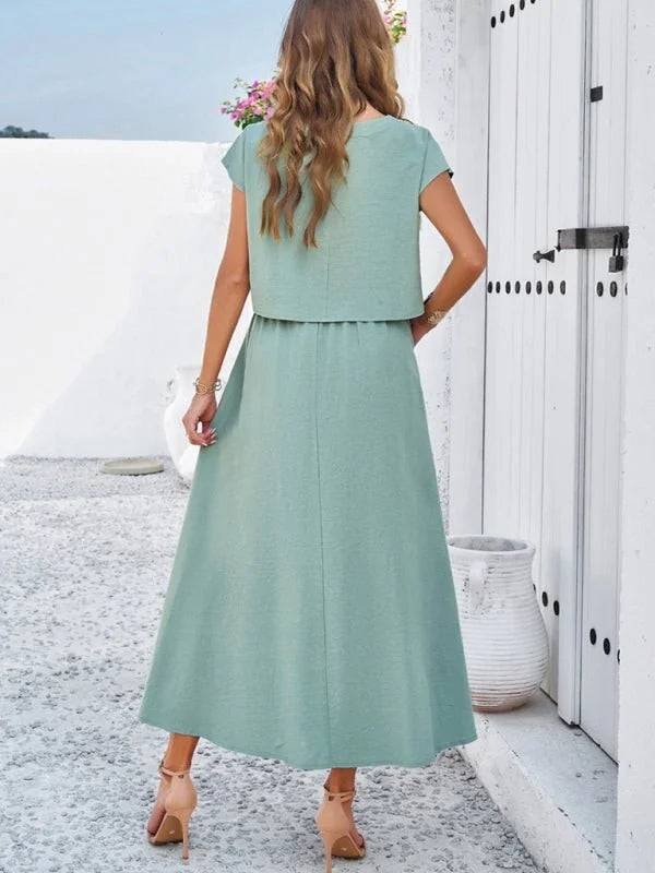 Sage green two-piece set with a cropped top and flowy midi skirt, shown from the back.