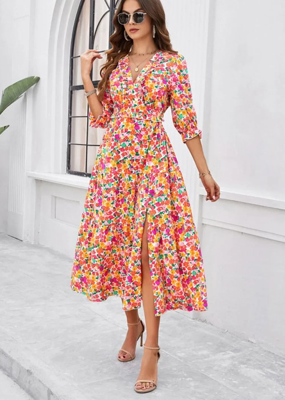 Floral print polyester midi dress with a V-neck, flutter sleeves, and a thigh-high slit.