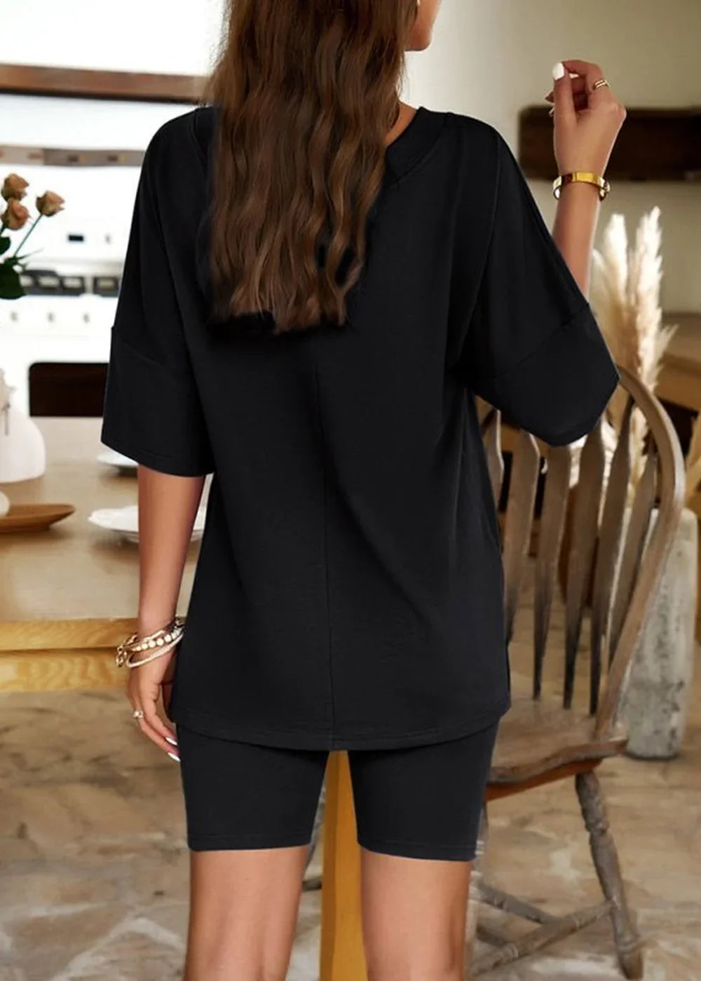 Black short suit set with oversized top and biker shorts, showing back view on model.