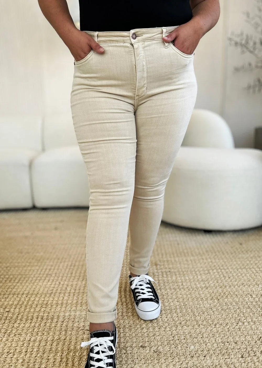 Close-up of bone colored jeans with a regular fit, showing texture and cuffed hems.