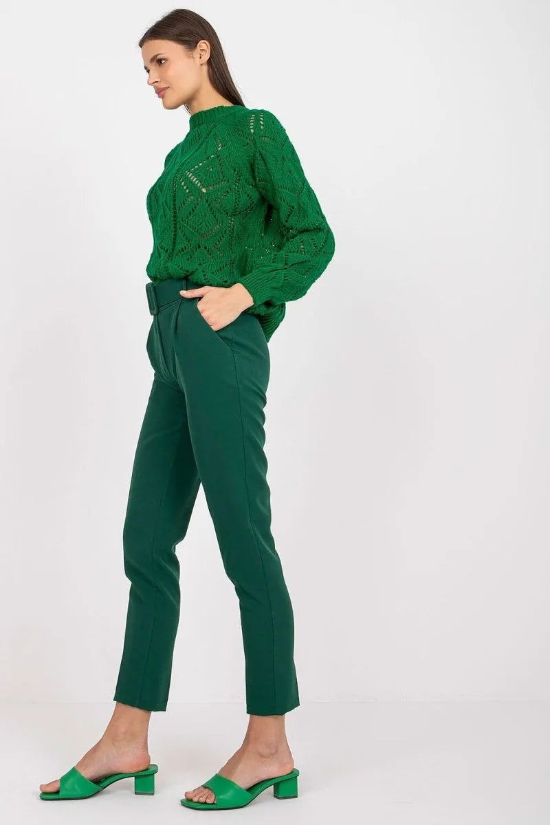 Woman in green high-waisted, belted, straight-leg pants with a textured green sweater.