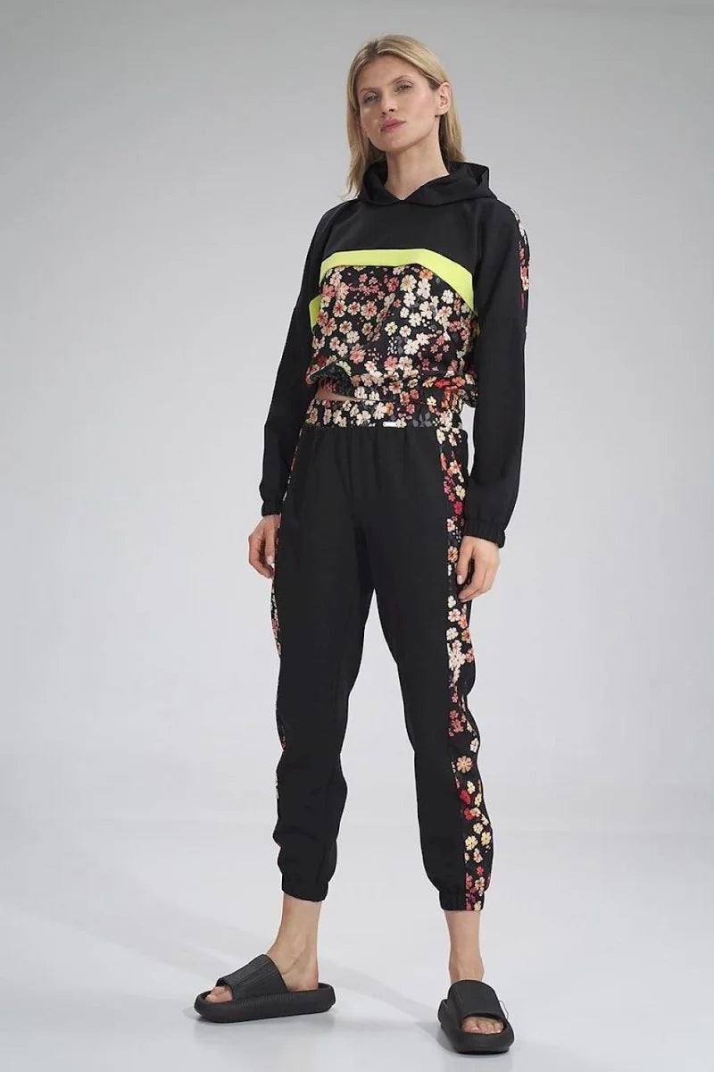 Black tracksuit with floral pattern down the sides and a neon yellow stripe across the chest.