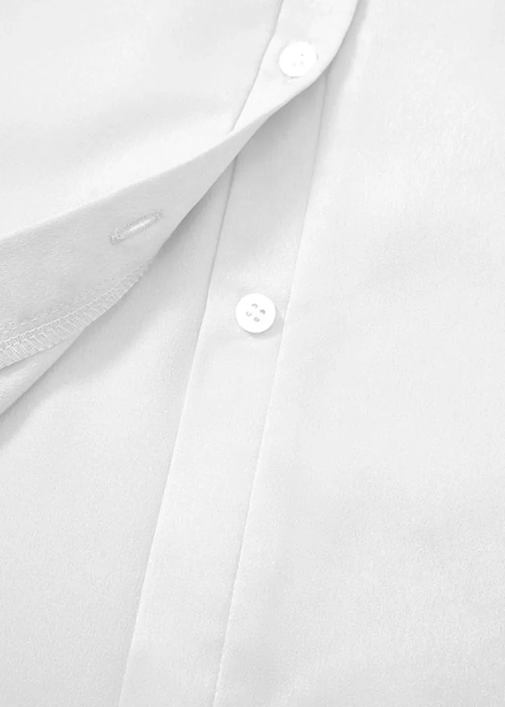 Close-up of a white polyester shirt showing two buttons and fabric texture.