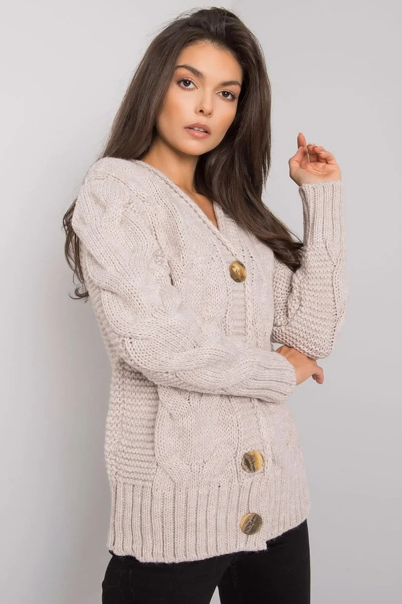 Beige cable knit cardigan with gold buttons, on model.