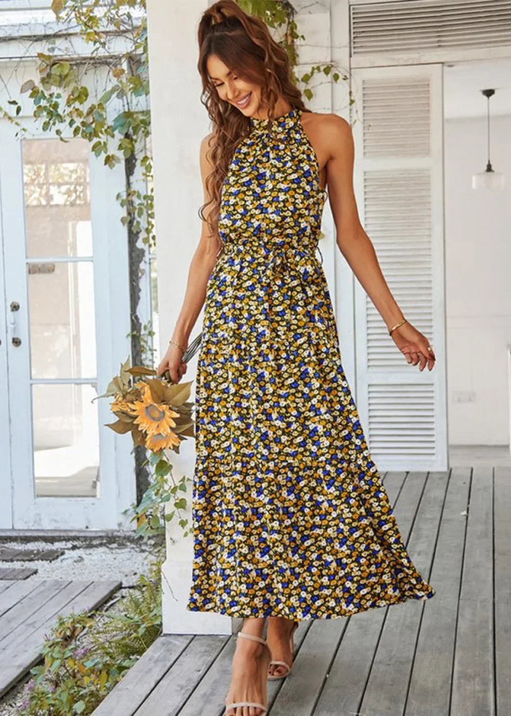 Yellow and blue floral print halter maxi dress with a tie waist, shown on a model.