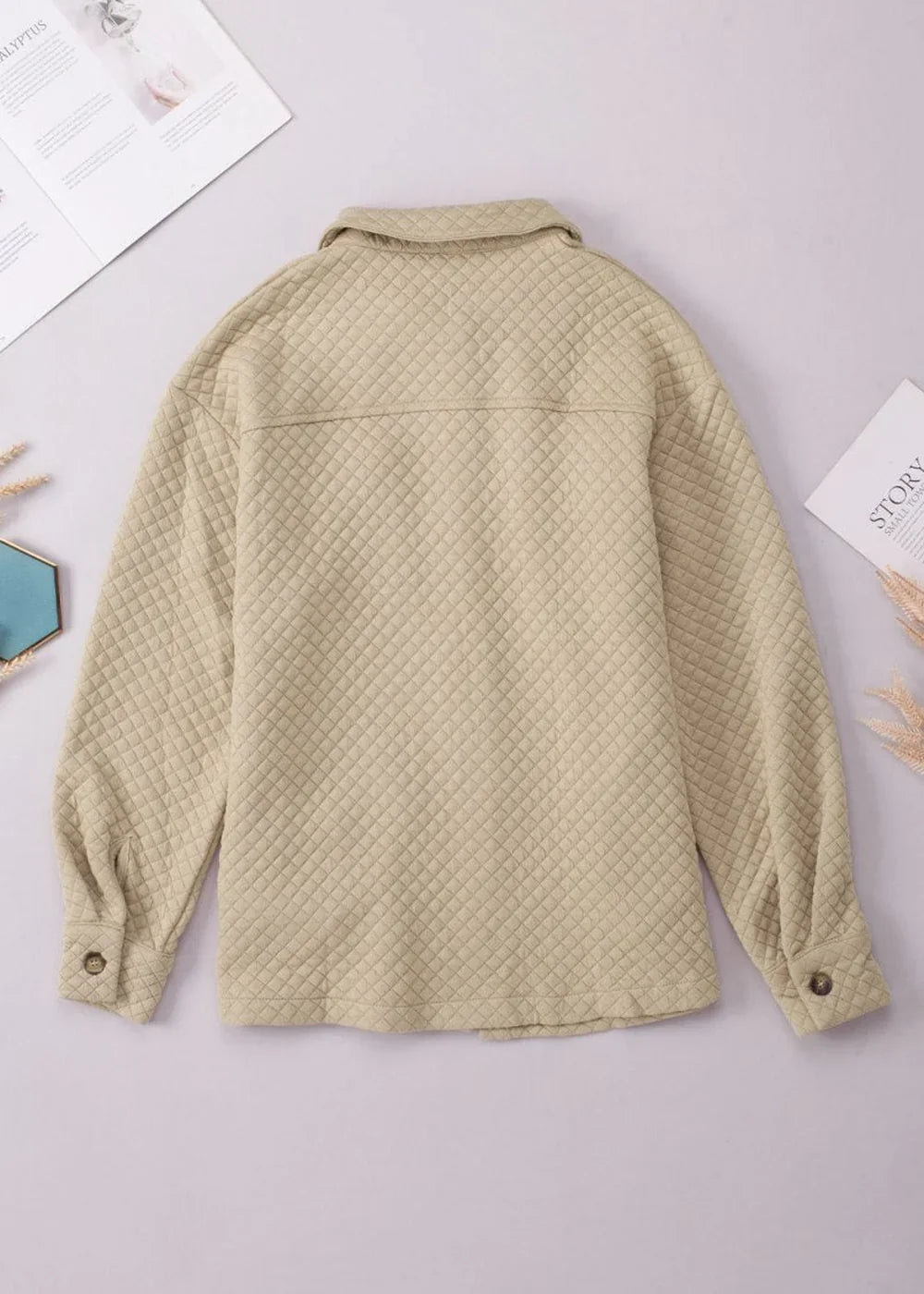Beige quilted shirt jacket with button cuffs, showing the back view.