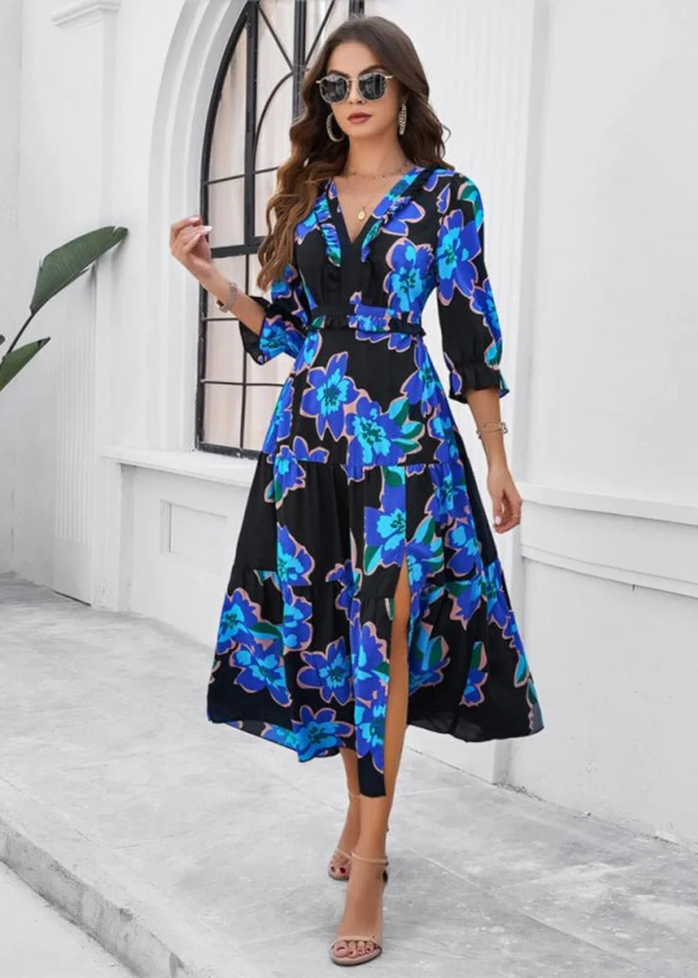Black and blue floral print dress with a v-neck and thigh-high slit, worn by a model.
