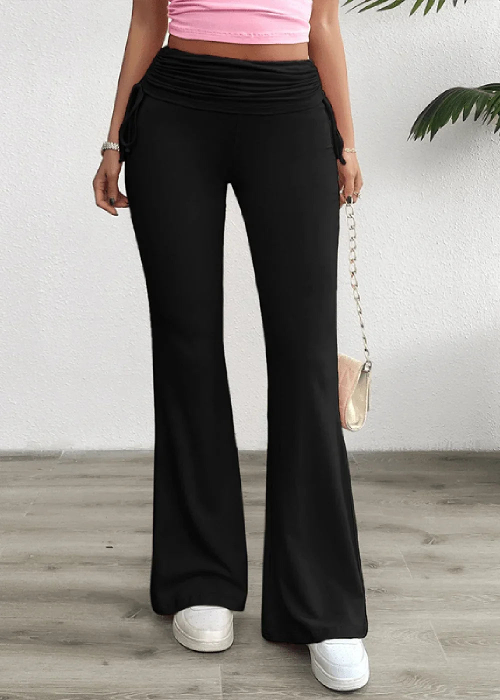 Black flared pants with a ruched waistband and drawstring details on a model.