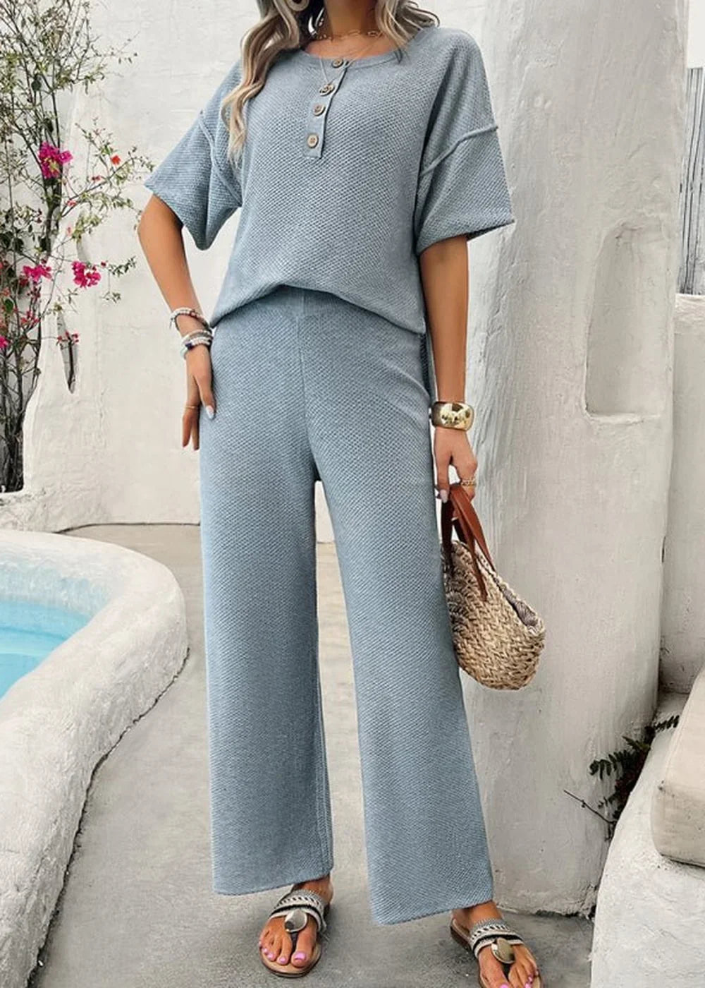 Light blue textured knit two-piece set with wide-leg pants and short-sleeve top on model.