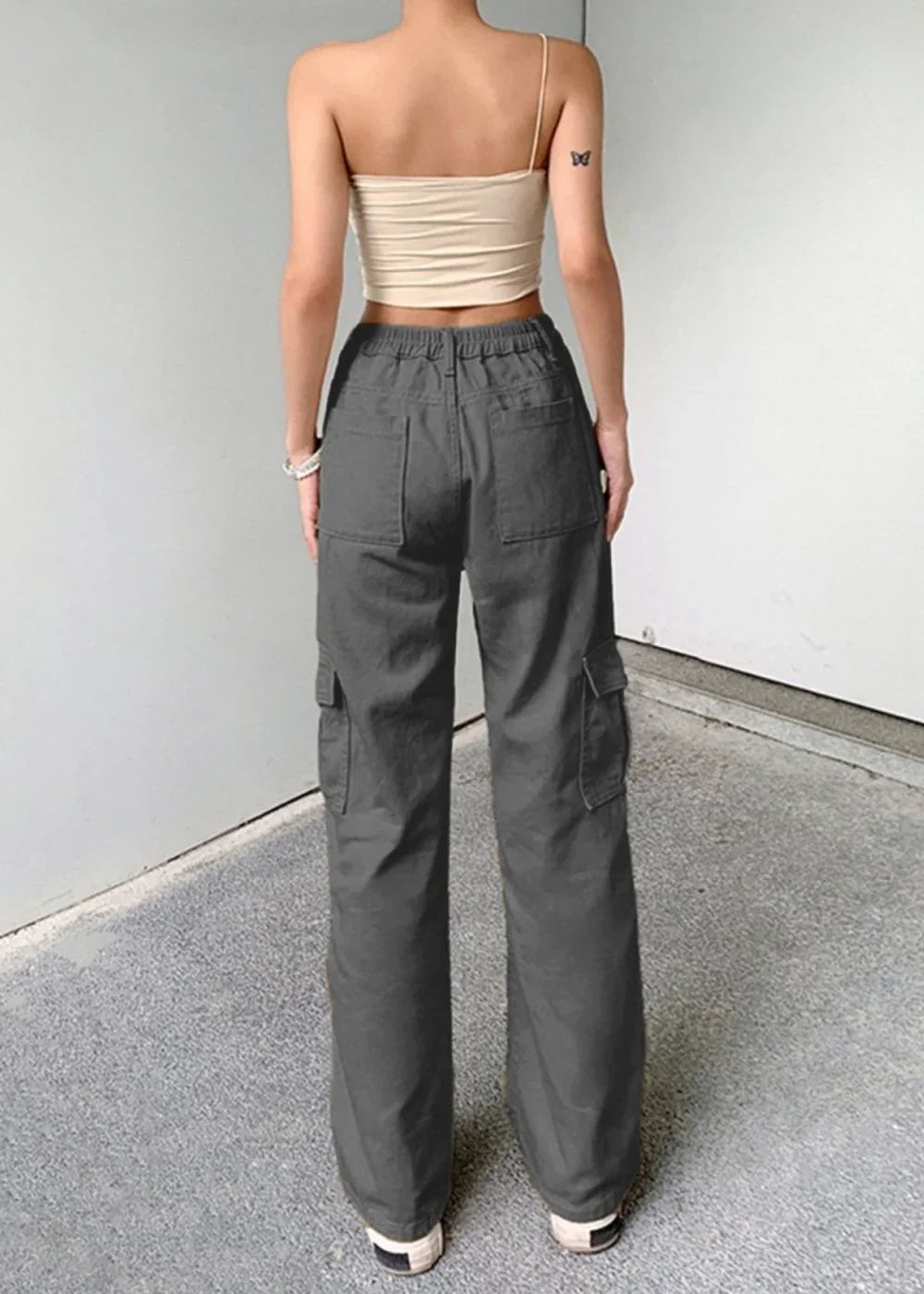 Dark grey cargo pants with a regular fit, featuring multiple pockets and a drawstring waist, shown from the back on a model.