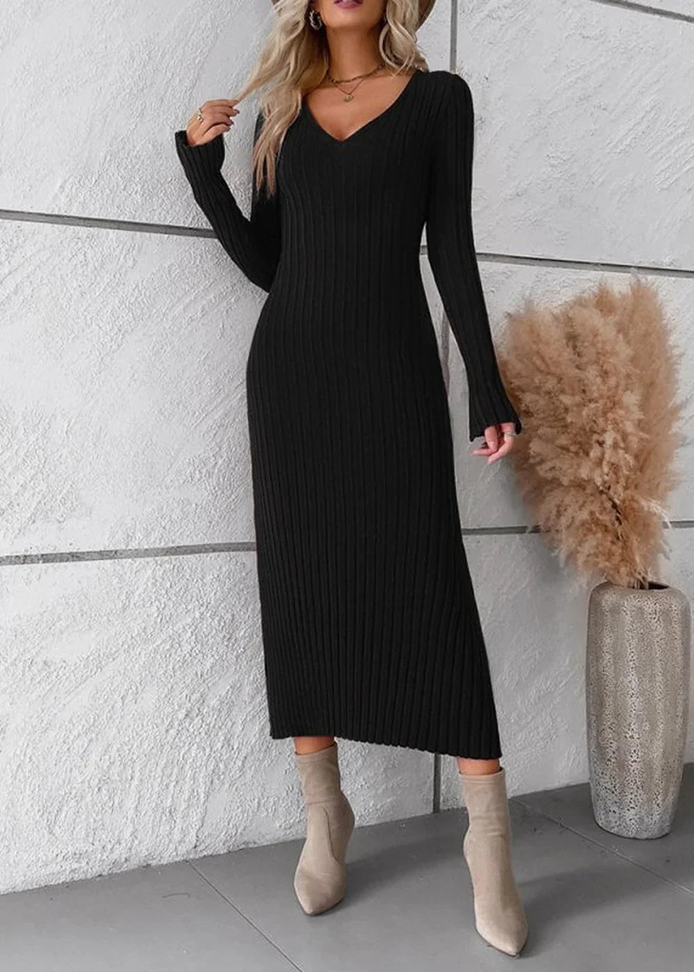 Black ribbed knit V-neck long sleeve midi sweater dress on model with beige ankle boots.
