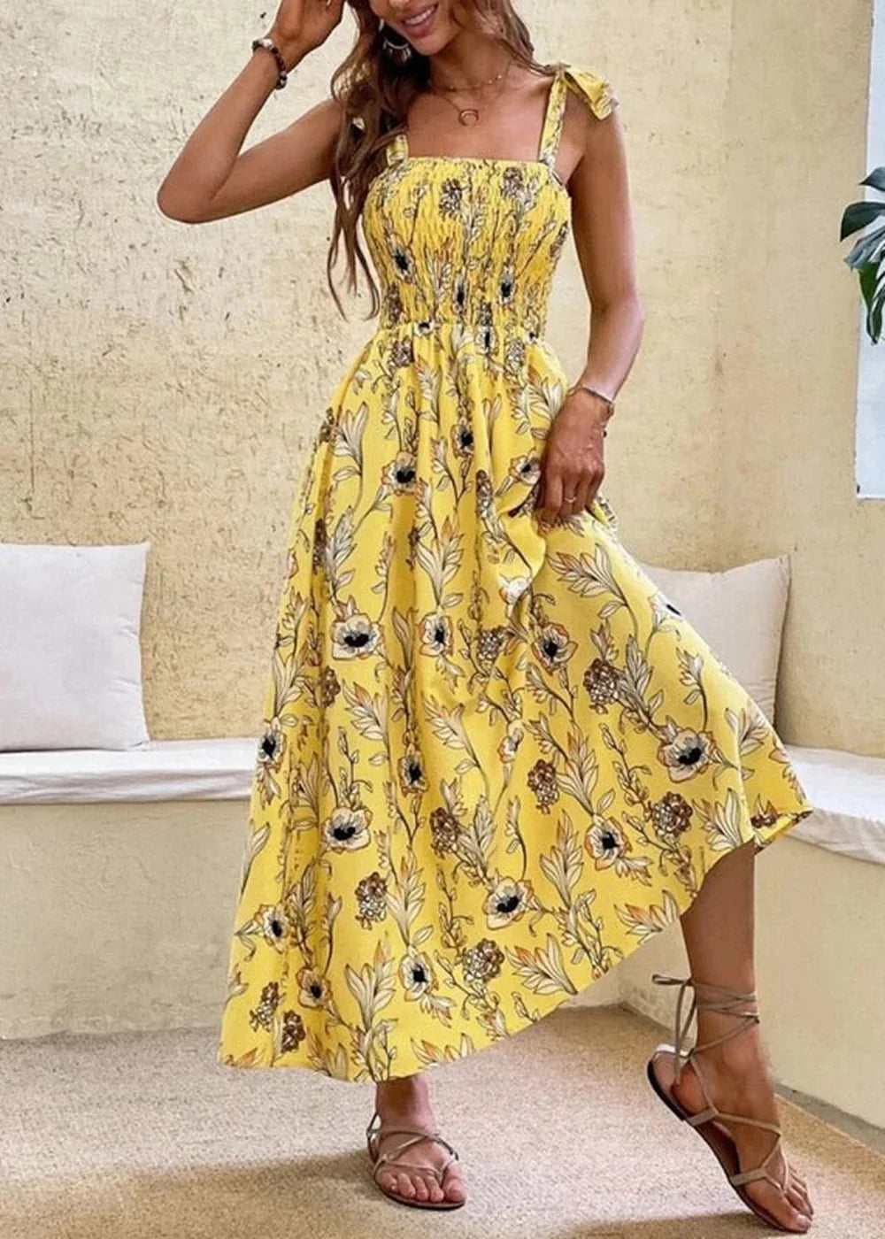 Yellow floral print midi dress with smocked bodice and tie straps, worn by a model.