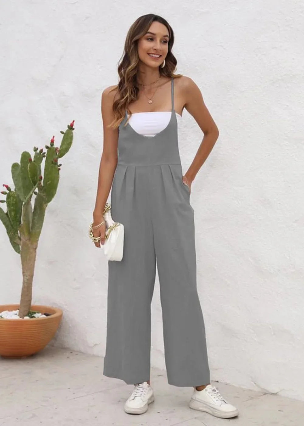 Gray wide-leg jumpsuit with spaghetti straps and a white bandeau top, worn by a model.