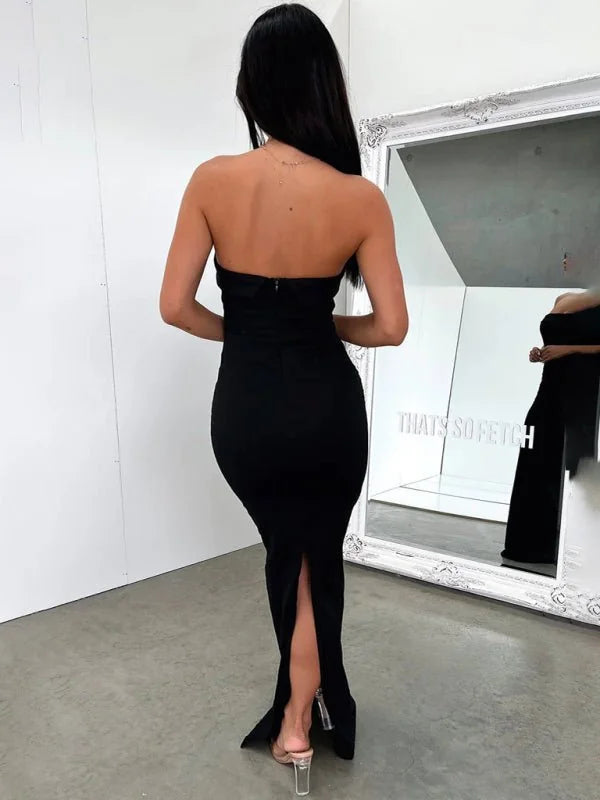 Back view of a black, strapless, floor-length dress with a high slit, on a model.