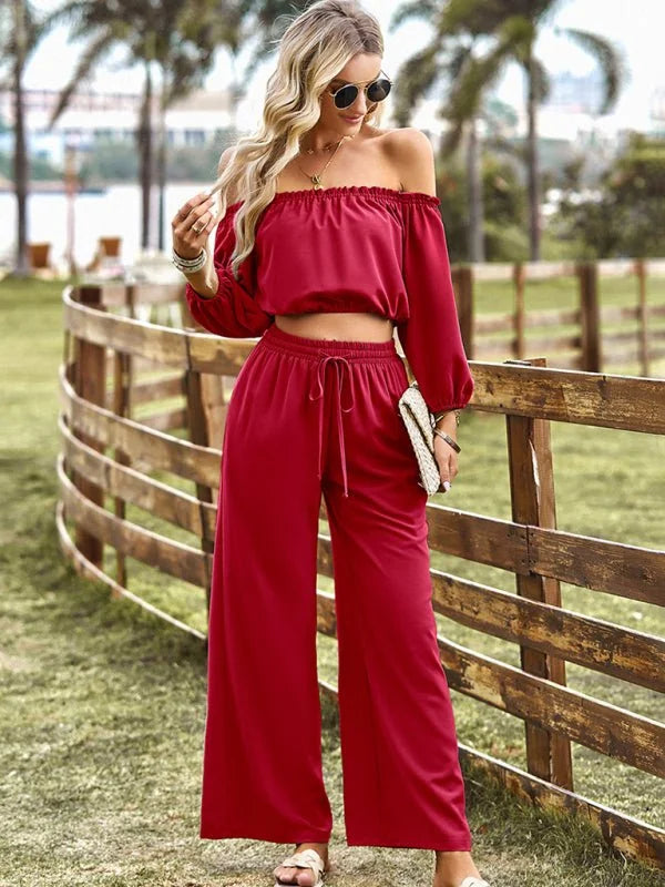Red off-the-shoulder crop top and wide-leg pants with drawstring waist, on model.