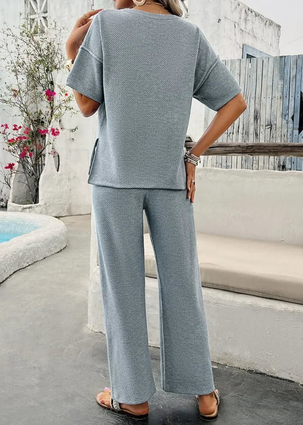 Light blue textured knit loungewear set with wide-leg pants and short-sleeve top on a model.