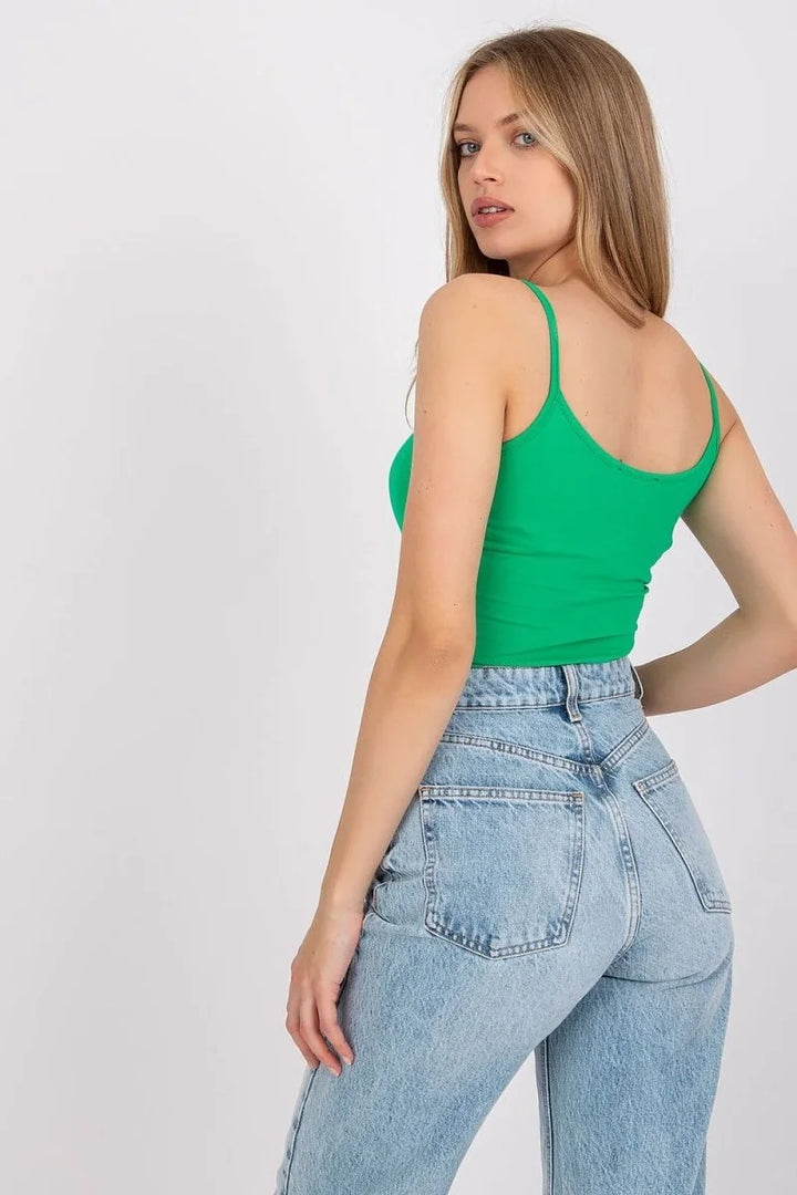 Green spaghetti strap crop top with light wash high-waisted denim jeans.