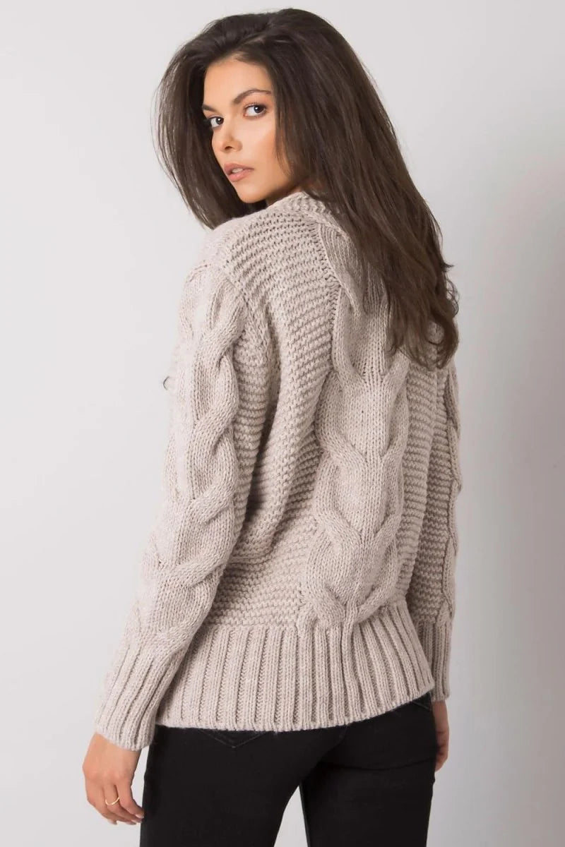 Cream cable knit sweater with ribbed cuffs and hem, worn by a model.