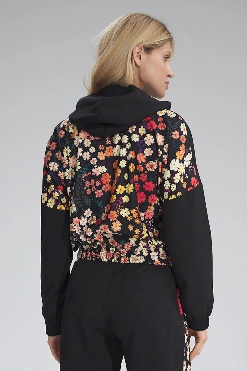 Back view of a black hooded jacket with a vibrant floral print on the front and sleeves.
