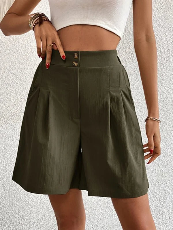 Olive green pleated shorts with a high waist and two button closure, on a model.