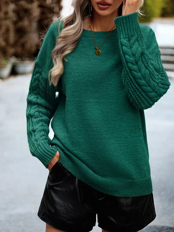 Emerald green acrylic sweater with cable knit sleeves on a model.