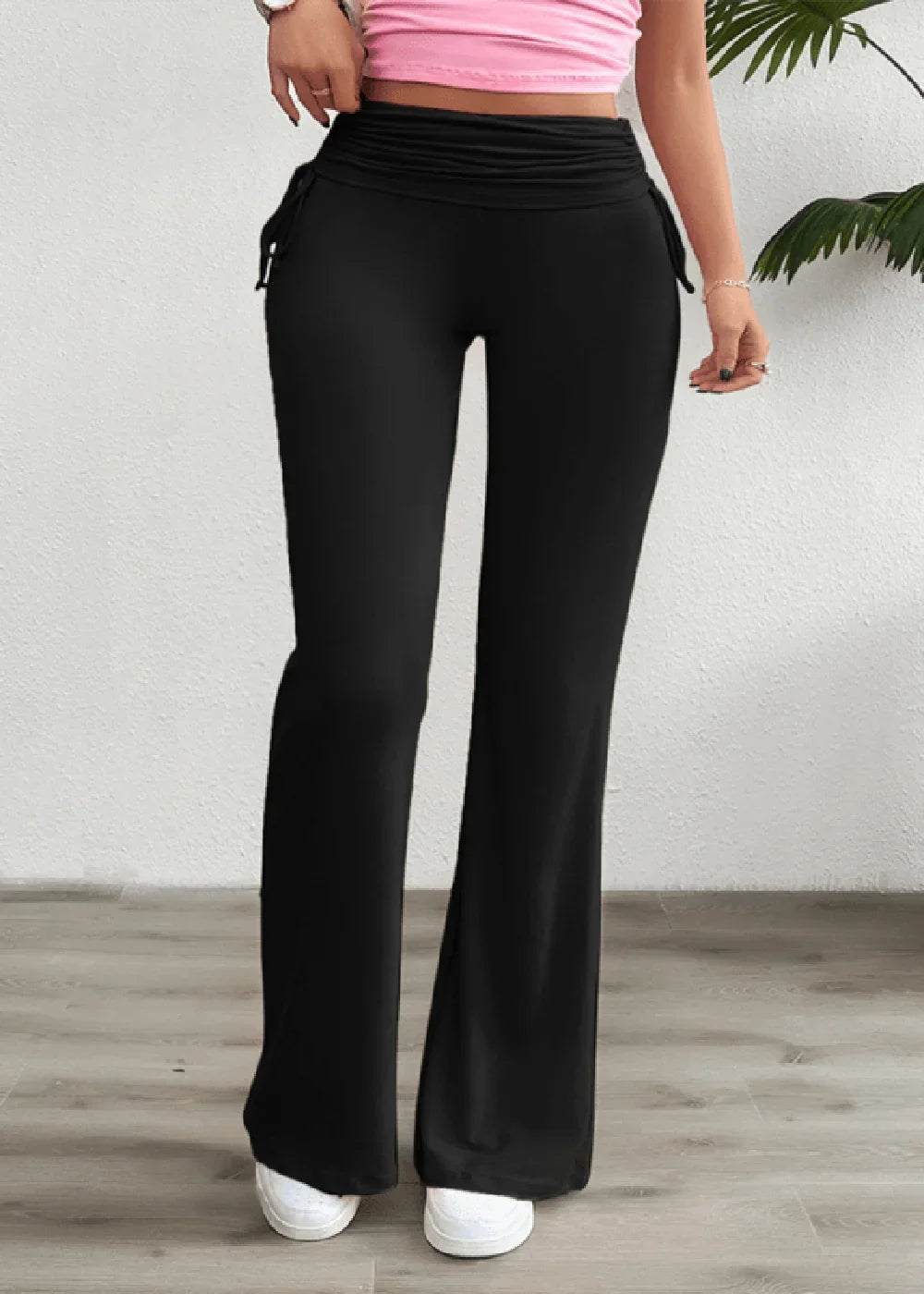 Black high-waisted flared pants with drawstring detail at the waist, on model.