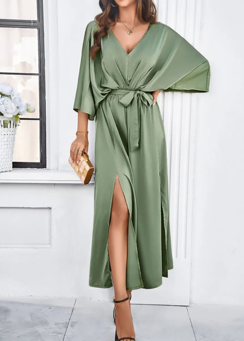 Sage green satin maxi dress with deep V-neck, flutter sleeves, and high leg slits.