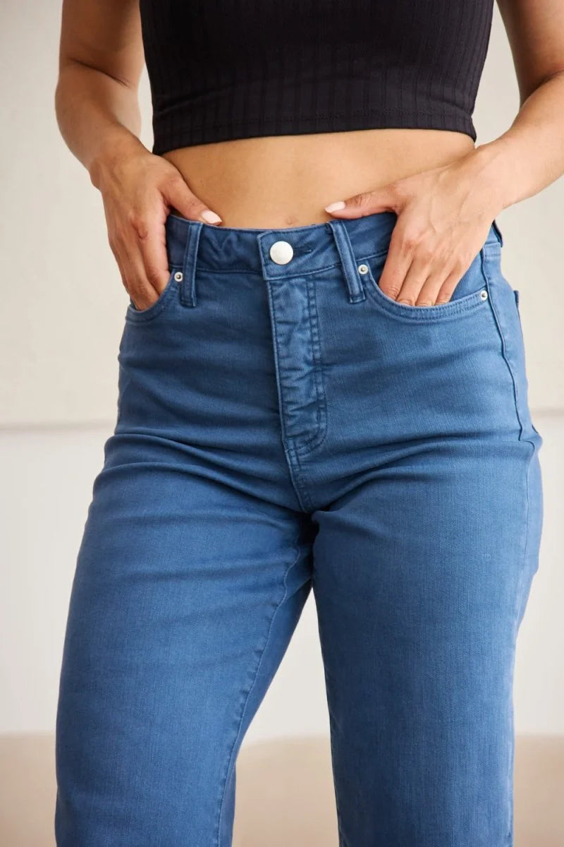 Close-up of blue denim jeans with a button closure and visible stitching detail.
