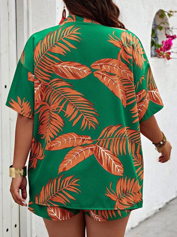 Green short suit with an orange palm leaf print, featuring a wide gold cuff bracelet.
