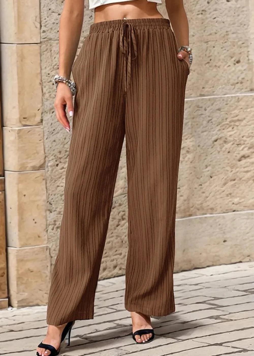 Brown textured wide-leg pants with drawstring waist and pockets, shown on model.