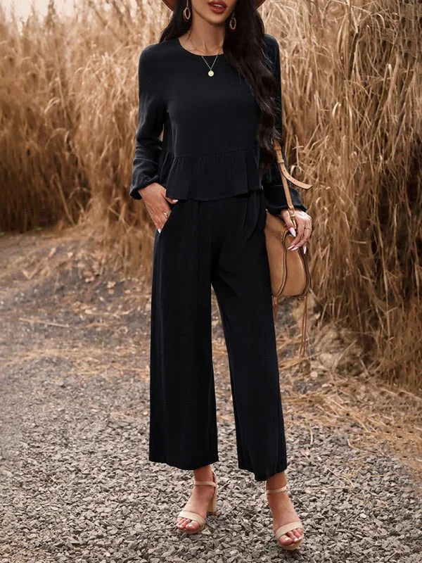 Black linen-blend wide-leg pants and peplum top on a model, styled with tan sandals and a brown crossbody bag.