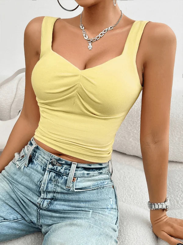 Yellow ruched sweetheart neckline tank top with thin straps, paired with light wash distressed jeans.