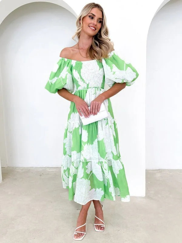 Off-the-shoulder lime green dress with white floral print, puff sleeves, and tiered skirt on a model.