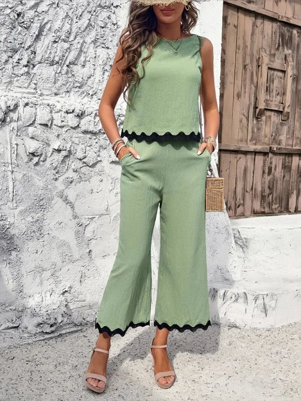 Light green sleeveless crop top and wide-leg pants set with scalloped black trim.
