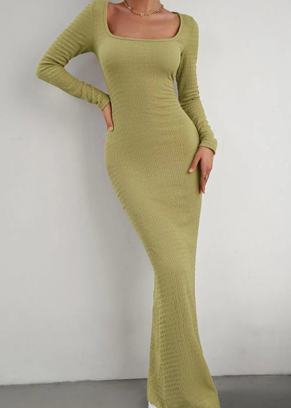 Olive green long-sleeve maxi dress with a square neckline and textured fabric, fitted on model.