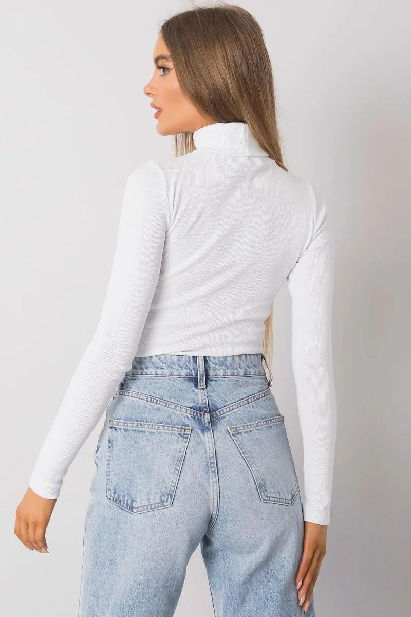 White ribbed turtleneck long-sleeve crop top on model with light wash denim jeans, back view.