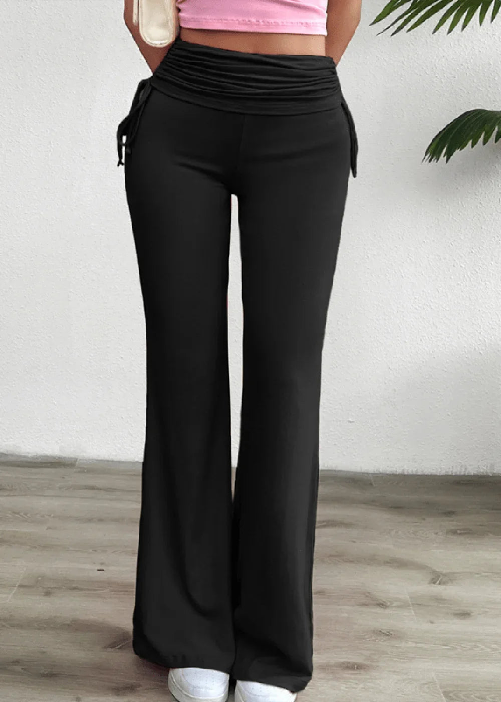 Black flared pants with ruched drawstring waist and ties on model.