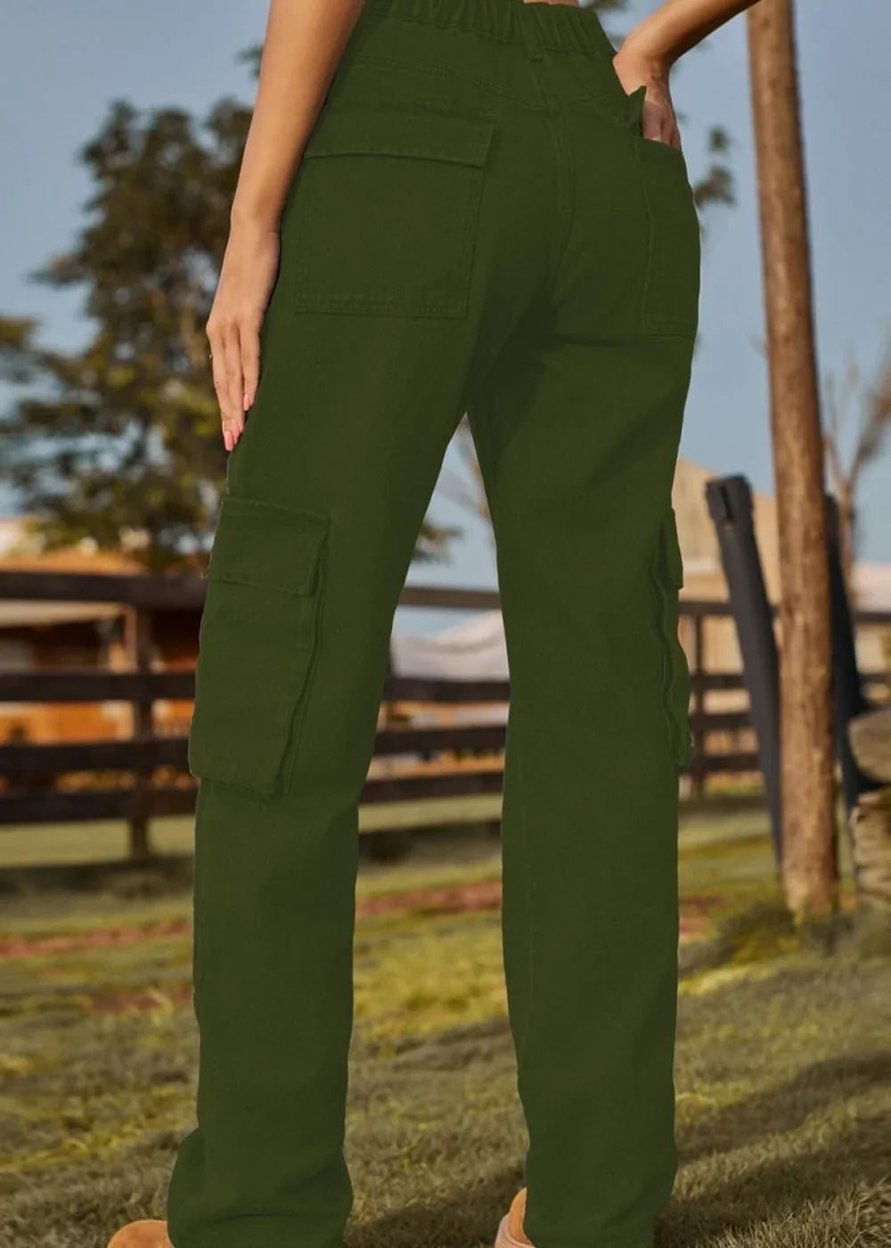 Back view of olive green cargo pants with patch pockets on a model.